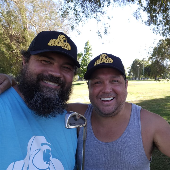 Friends wearing Nuwud logo hats on a golf course